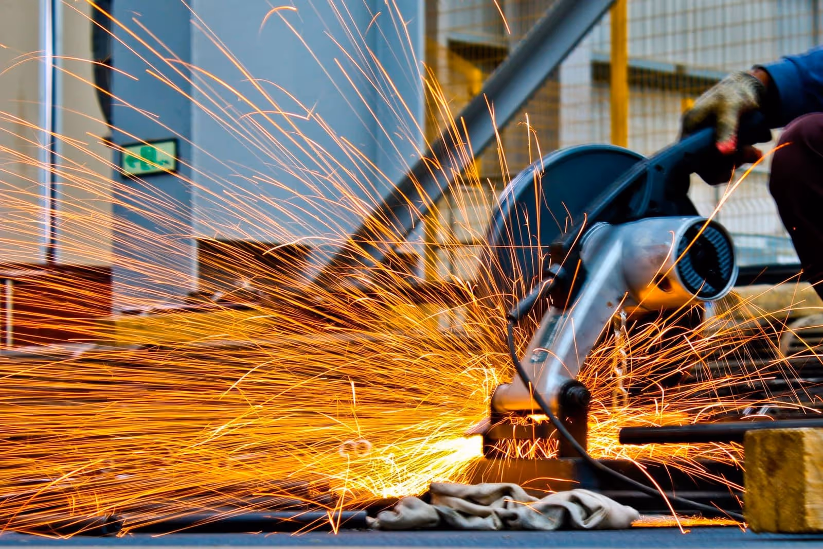 Cut-off saw slicing a steel bar — trail of sparks during cutting in the workshop