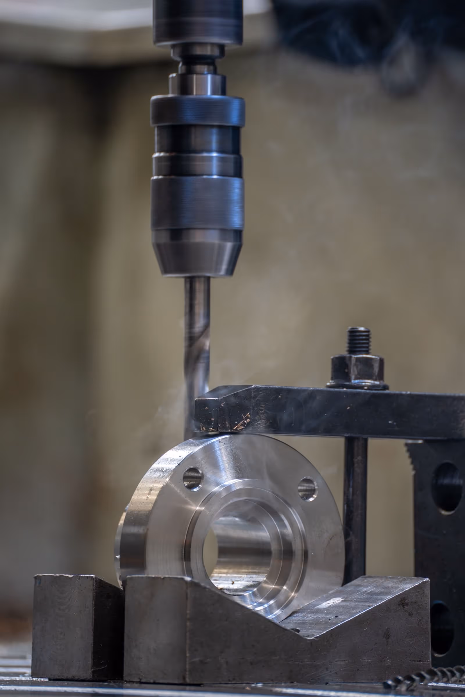 Drill press boring a steel flange in the workshop