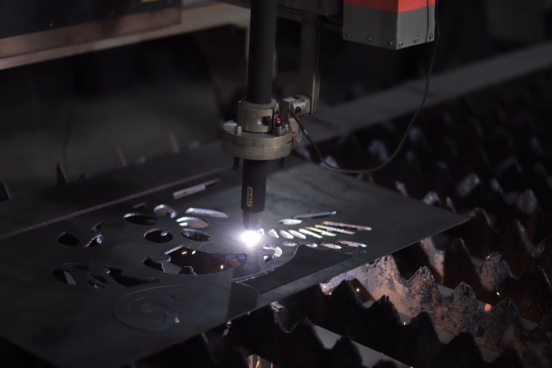 Torcia da taglio CNC in azione su lamiera d'acciaio con scintille durante la lavorazione
